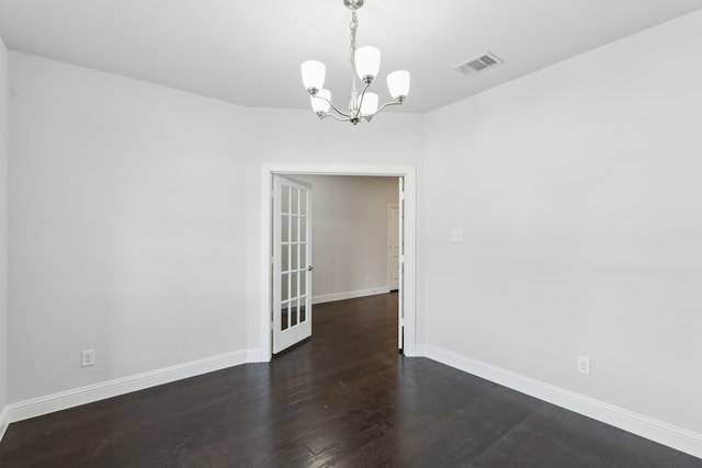 unfurnished room featuring dark wood-style floors, a chandelier, visible vents, and baseboards