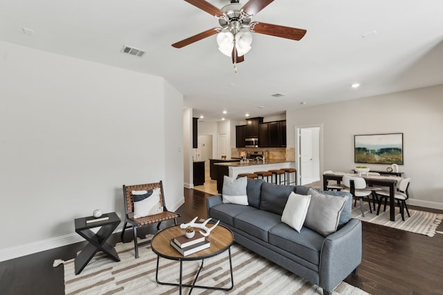 living room featuring baseboards, visible vents, ceiling fan, wood finished floors, and recessed lighting