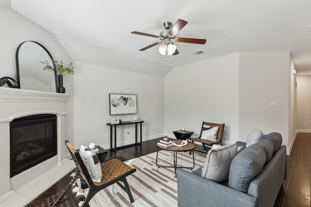 living room with lofted ceiling, wood finished floors, visible vents, baseboards, and a glass covered fireplace