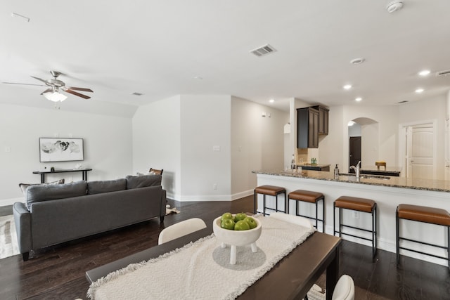 dining area featuring visible vents, arched walkways, dark wood-type flooring, and recessed lighting