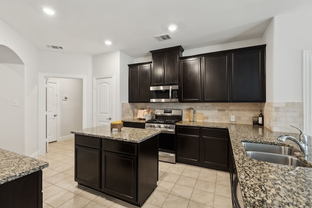 kitchen with backsplash, visible vents, stainless steel appliances, and a sink