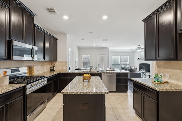 kitchen with a peninsula, visible vents, open floor plan, appliances with stainless steel finishes, and a center island