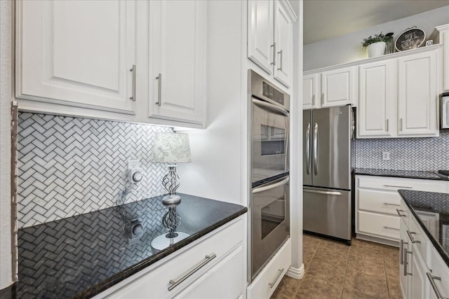 kitchen featuring appliances with stainless steel finishes, white cabinets, decorative backsplash, and tile patterned floors