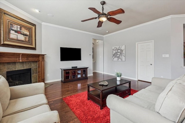 living room with a ceiling fan, crown molding, baseboards, and wood finished floors