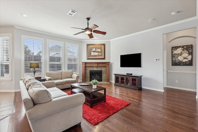 living room featuring baseboards, visible vents, wood finished floors, and ornamental molding