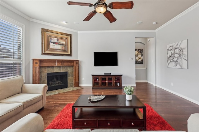 living room featuring baseboards, crown molding, and wood finished floors