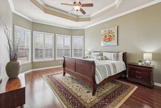 bedroom featuring crown molding, a tray ceiling, dark wood finished floors, and baseboards