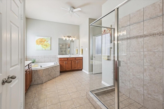 bathroom featuring a stall shower, tile patterned flooring, a garden tub, and vanity