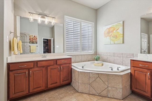 bathroom with a garden tub, tile patterned flooring, and vanity