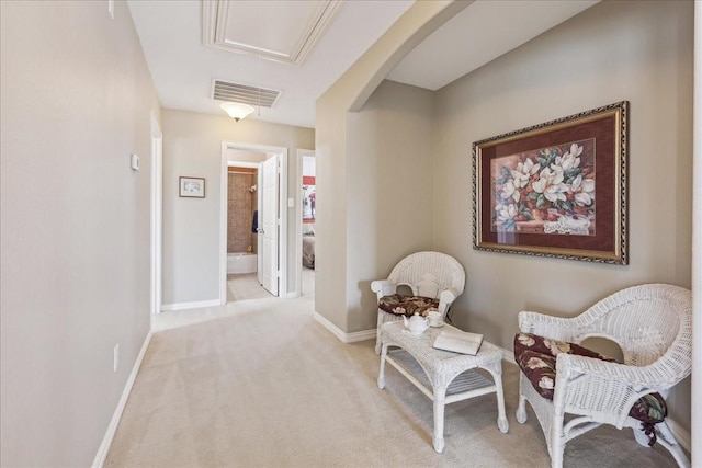 living area featuring arched walkways, baseboards, visible vents, and carpet flooring