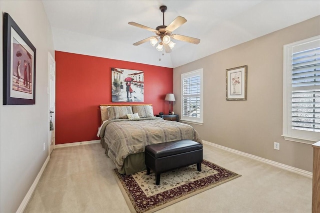 bedroom featuring light carpet, vaulted ceiling, a ceiling fan, and baseboards