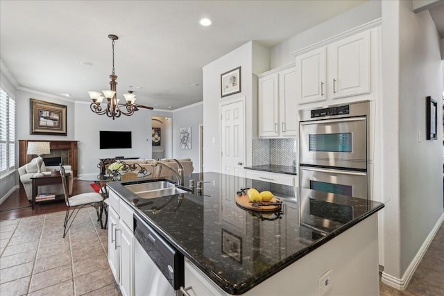 kitchen with stainless steel appliances, a spacious island, a fireplace, a sink, and open floor plan