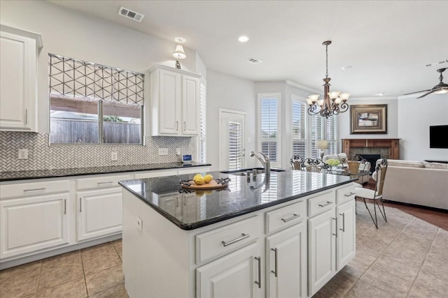 kitchen featuring a fireplace, visible vents, a sink, and decorative backsplash