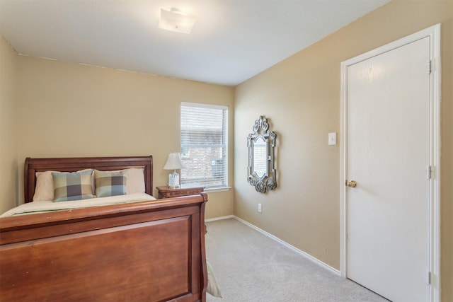 bedroom with baseboards and light carpet