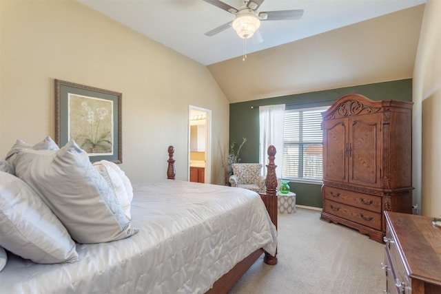 bedroom featuring ceiling fan, lofted ceiling, ensuite bathroom, and light carpet