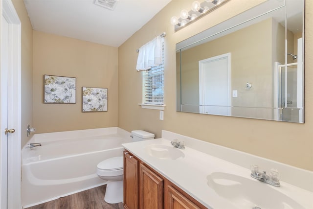 bathroom with toilet, a bath, visible vents, and a sink