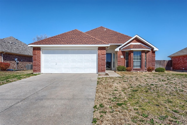 ranch-style home with fence, roof with shingles, concrete driveway, a garage, and brick siding