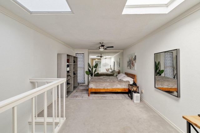 bedroom featuring ornamental molding, a skylight, carpet flooring, and baseboards