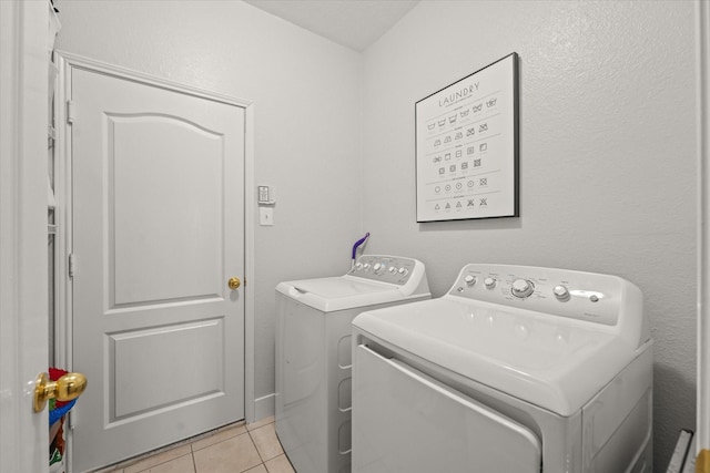 washroom with laundry area, light tile patterned floors, and independent washer and dryer