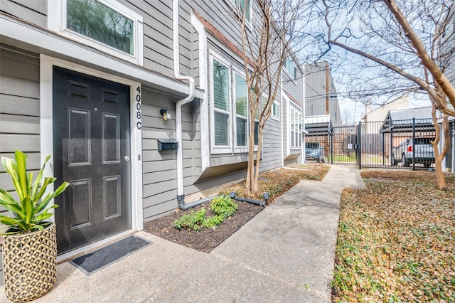 property entrance featuring a gate, fence, and a residential view