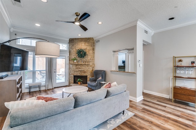 living room with a fireplace, wood finished floors, and visible vents