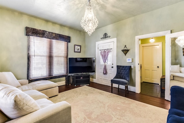 living room featuring baseboards, an inviting chandelier, and wood finished floors