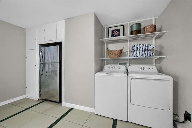 washroom with laundry area, baseboards, separate washer and dryer, and light tile patterned floors