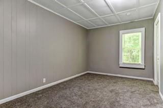 spare room featuring carpet floors and baseboards