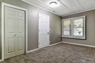 unfurnished room with carpet and baseboards