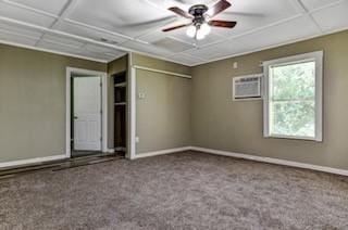 carpeted empty room with a paneled ceiling, baseboards, a ceiling fan, and a wall mounted AC