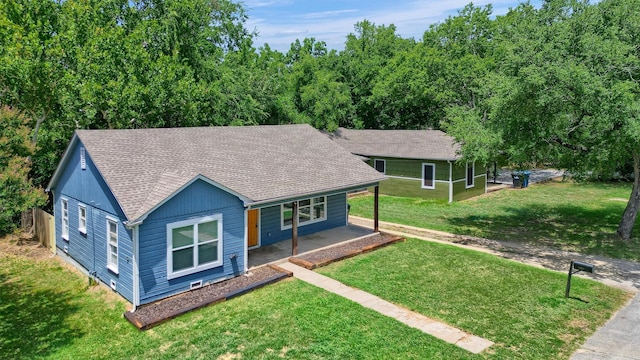 single story home featuring a porch, a shingled roof, and a front lawn