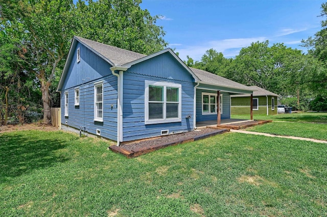 single story home featuring a shingled roof, a porch, and a front lawn