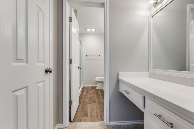 full bathroom with toilet, wood finished floors, vanity, baseboards, and an enclosed shower