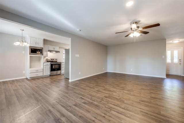 unfurnished living room featuring baseboards, wood finished floors, and ceiling fan with notable chandelier