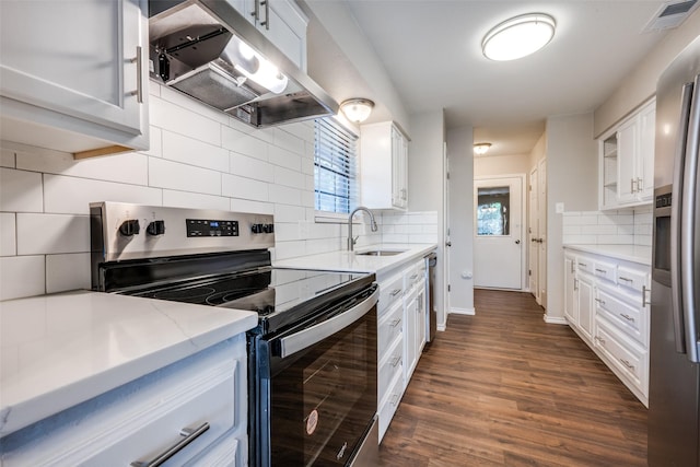 kitchen featuring dark wood finished floors, stainless steel appliances, visible vents, a sink, and under cabinet range hood