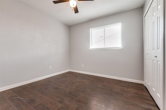 unfurnished room with ceiling fan, baseboards, and dark wood finished floors