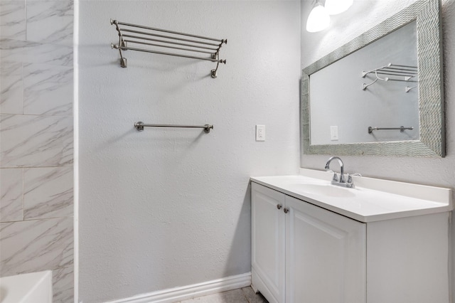 bathroom with a textured wall, vanity, baseboards, a shower, and a bathtub