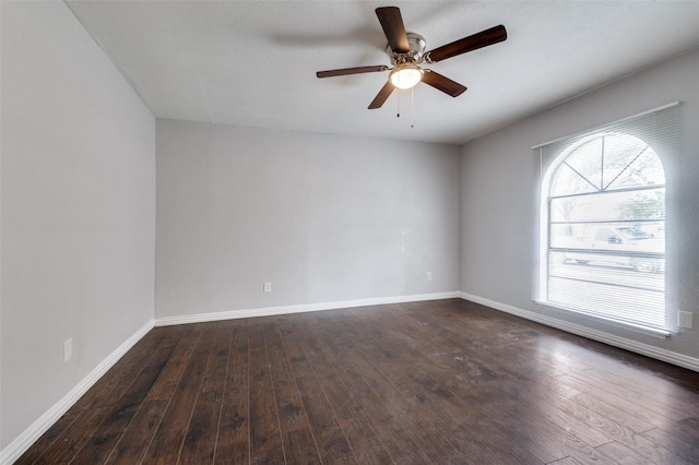 unfurnished room featuring dark wood-type flooring, a wealth of natural light, baseboards, and a ceiling fan