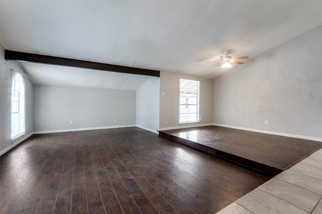 unfurnished living room featuring vaulted ceiling with beams, wood finished floors, a ceiling fan, and baseboards