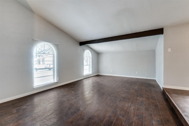 unfurnished room featuring dark wood-type flooring, lofted ceiling with beams, and baseboards