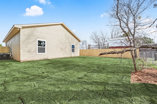 view of property exterior featuring central AC unit, a lawn, and a fenced backyard