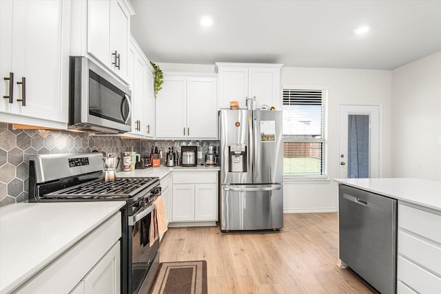 kitchen featuring tasteful backsplash, stainless steel appliances, light countertops, and light wood-style flooring