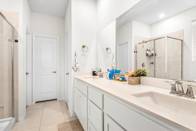 full bath with double vanity, tile patterned floors, a sink, and a shower stall