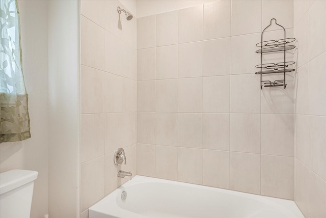 bathroom featuring bathtub / shower combination and toilet