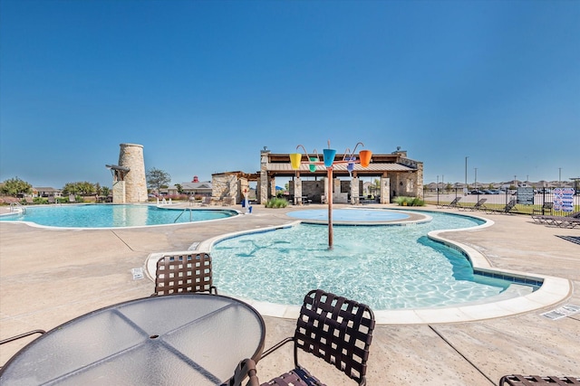 community pool with a patio and fence