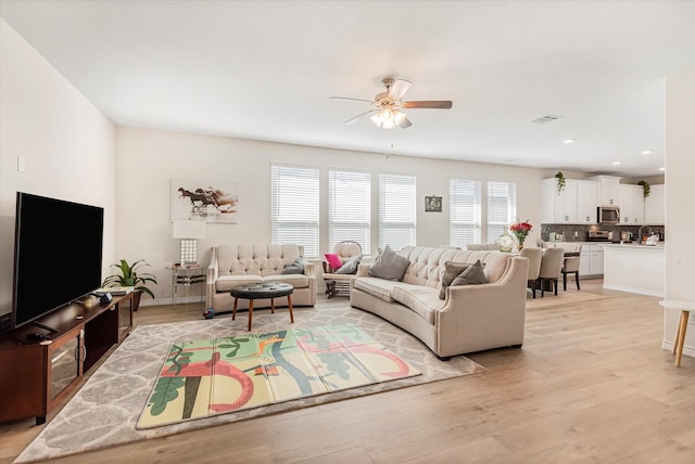 living area with ceiling fan, light wood-style flooring, recessed lighting, visible vents, and baseboards