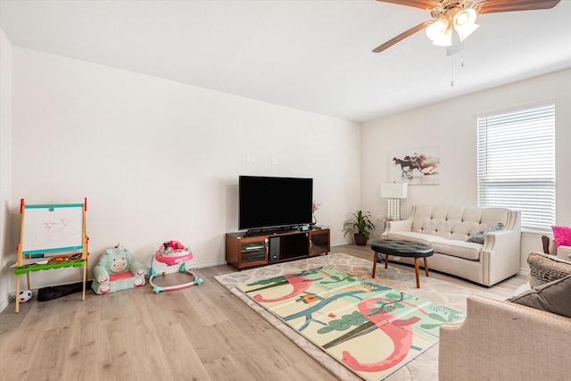 living area with ceiling fan, baseboards, and wood finished floors