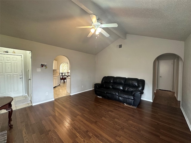 sitting room with vaulted ceiling with beams, visible vents, arched walkways, and wood finished floors