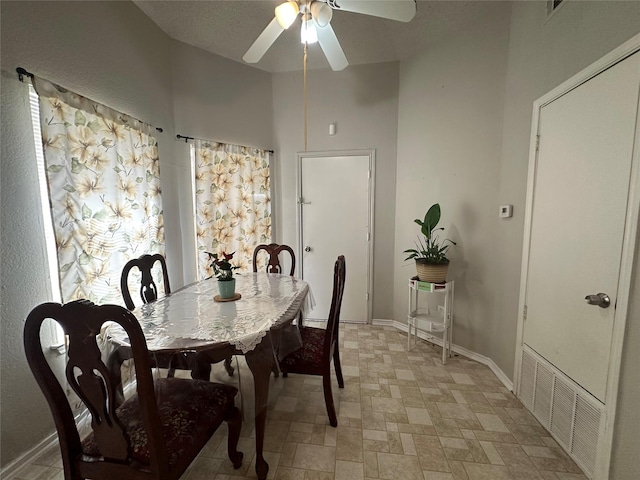 dining space with baseboards and a ceiling fan