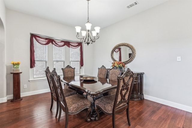 dining room with dark wood-style floors, visible vents, baseboards, and a notable chandelier